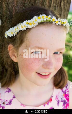 Nine year-old girl with a daisy chain on her head in the shape of a crown. UK. (123) Stock Photo