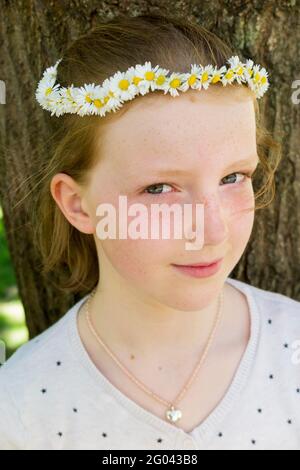 Eleven year-old girl with a daisy chain on her head in the shape of a crown. UK. (123) Stock Photo