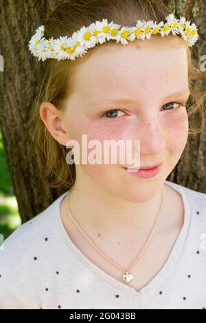 Eleven year-old girl with a daisy chain on her head in the shape of a crown. UK. (123) Stock Photo