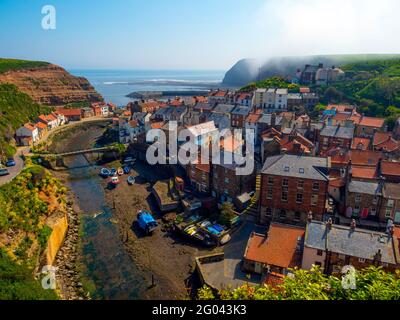 View looking seawards over the harbour of the North Yorkshire Village of Staithes with Cowbar on the North side of Roxby Beck Stock Photo