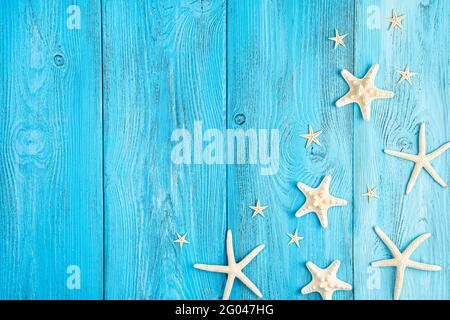 Starfish of different shapes on a blue background. Summer background. Copy space. Stock Photo