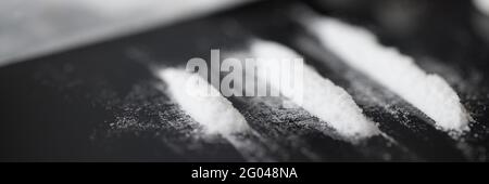 Closeup of white narcotic powder tracks on black background Stock Photo
