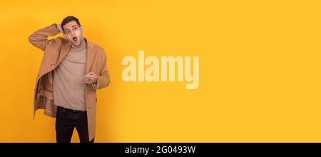 isolated young man with mobile phone and surprise expression Stock Photo
