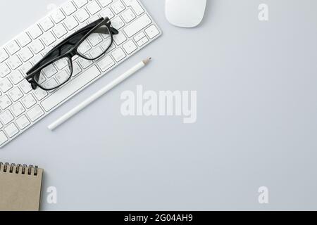 Glasses mouse pencil keyboard and notepad on white background Stock Photo