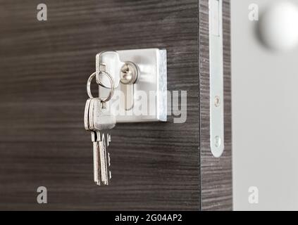 Close up of keys in the lock of a new house. The entrance door. Real estate. Mortgage. Stock Photo