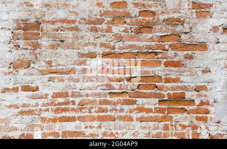 Brick old wall. Cleaned plaster. Red brick. Brick wall of old bricks. Stock Photo