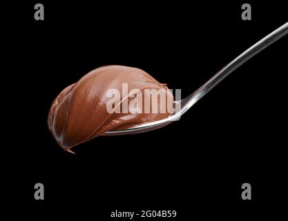 spoon of melted chocolate hazelnut cream on black background Stock Photo