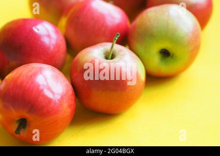 Apples are ripe red on a yellow background with a place for the inscription. Stock Photo