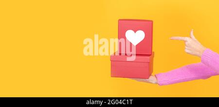 isolated hands with stacked gift boxes with heart Stock Photo
