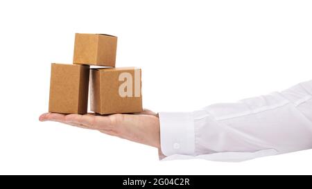 Three cardboard boxes of different sizes on the palm of a man isolated on a white background. Stock Photo