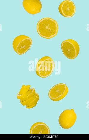 Floating levitating fresh and sliced lemon on pastel blue background. Vitamins, healthy diet concept. Minimal fruit idea. Sliced lemon floating in the Stock Photo