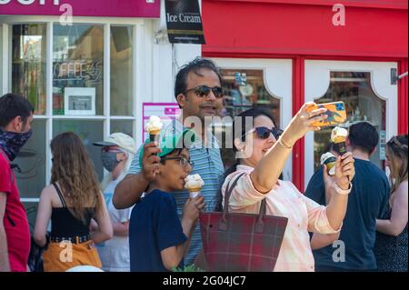 Windsor, Berkshire, UK. 31st May, 2021. Selfies and ice creams. Windsor was packed with locals and visitors today as the warm sunshine brought people into the town for the Bank Holiday Monday. Following the lifiting of most of the Covid-19 restrictions the town was booming today with people eating outside, going on river trips and enjoying time with their families and friends. Credit: Maureen McLean/Alamy Live News
