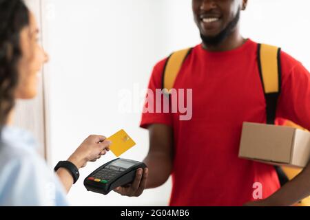 Portrait of black man holding POS machine for payment Stock Photo