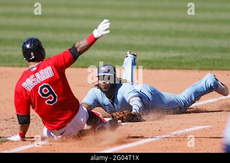 CLEVELAND, OH - May 30: Vladimir Guerrero Jr. (27) of the Toronto Blue Jays dives to the first base bag ahead of Eddie Rosario (9) of the Cleveland In Stock Photo