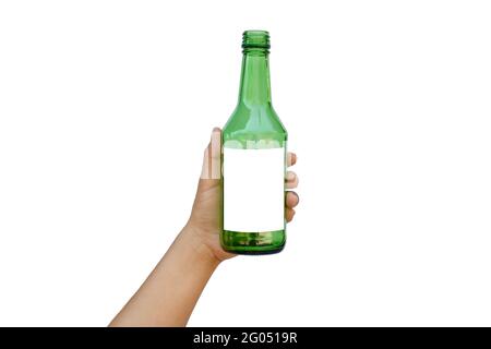 Hand holding an empty green glass bottle with a text space isolated on a white background with the clipping path. Stock Photo