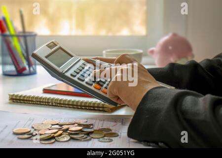 Close-up of women using calculators and note-taking, accounting reports, cost-calculation ideas and saving money. Stock Photo