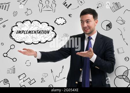 Business, technology, internet and network concept. Young businessman thinks over the steps for successful growth: Implementation Stock Photo