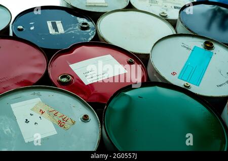 Old chemical barrels. Blue, green, and red oil drum. Steel oil tank. Toxic waste warehouse. Hazard chemical barrel with warning label. Industrial. Stock Photo