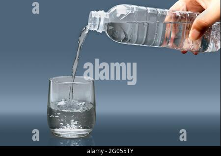 Man's hand pouring water into a glass. Stock Photo