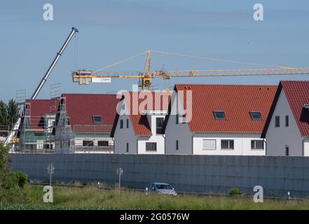 Nieder Erlenbach, Germany. 31st May, 2021. Scaffolding stands on the houses of a new housing estate in Frankfurt's Nieder-Erlenbach district. Experts are critical of the development of grassland in Hesse. (to dpa 'Land consumption in Hesse') Credit: Boris Roessler/dpa/Alamy Live News Stock Photo