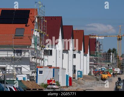 Nieder Erlenbach, Germany. 31st May, 2021. Scaffolding stands on a house in a new housing development in Frankfurt's Nieder-Erlenbach district. Experts are critical of the development of grassland in Hesse. (to dpa 'Land consumption in Hesse') Credit: Boris Roessler/dpa/Alamy Live News Stock Photo
