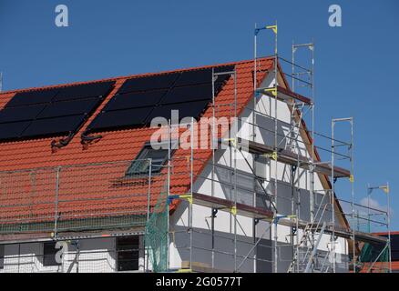 Nieder Erlenbach, Germany. 31st May, 2021. Scaffolding stands on a house in a new housing development in Frankfurt's Nieder-Erlenbach district. Experts are critical of the development of grassland in Hesse. (to dpa 'Land consumption in Hesse') Credit: Boris Roessler/dpa/Alamy Live News Stock Photo