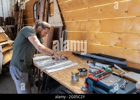 Man using a knife on a workbench Stock Photo