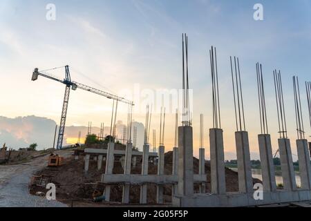 Concrete column structure of the retaining wall and Construction crane for laying large steel pipes for drinking water project under town planning, La Stock Photo