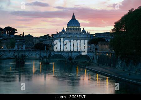 Rome, Italy.  Sant'Angelo bridge and St Peter's Basilica at dusk.  The historic centre of Rome, including the Vatican, are a UNESCO World Heritage Sit Stock Photo