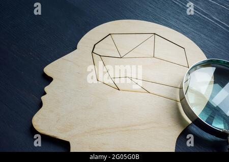 Mental health and memory problems. Head with a puzzle inside and a magnifying glass. Stock Photo