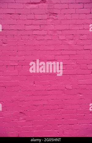 A new paint job on an old brick wall creates a colourful  textured background Stock Photo
