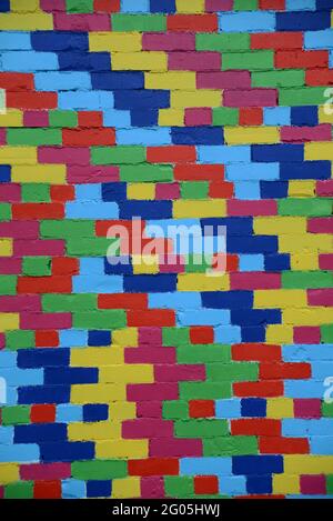 A new paint job on an old brick wall creates a colourful  textured background Stock Photo