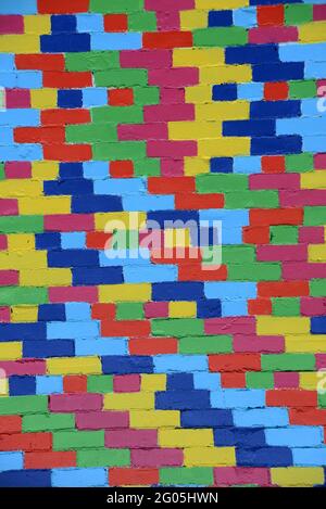 A new paint job on an old brick wall creates a colourful  textured background Stock Photo