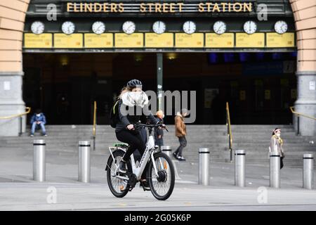 Melbourne, Australia. 28th May, 2021. A woman wearing face mask rides in Melbourne, Australia, May 28, 2021. The Australian state of Victoria went into the fifth day of its lockdown on Tuesday with the number of COVID-19 cases in the latest outbreak having risen to 54. Credit: Bai Xue/Xinhua/Alamy Live News Stock Photo