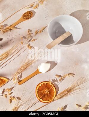 Home made, natural cosmetics. Spa composition with wooden spoons with fresh, natural ingredients for preparing organic scrub, ears of rye and wheat Stock Photo