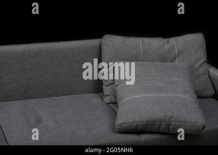 Gray pillows on the couch. Sofa on black background. Soft furniture Stock Photo