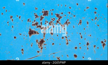 Blue peeling paint on the wall. An old concrete wall with cracked, peeling paint. Weathered rough painted surface Stock Photo