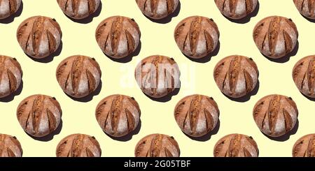 Fresh homemade rustic rye round bread seamless pattern isolated on yellow background, top view. Can be used as food background, base for textiles, pac Stock Photo