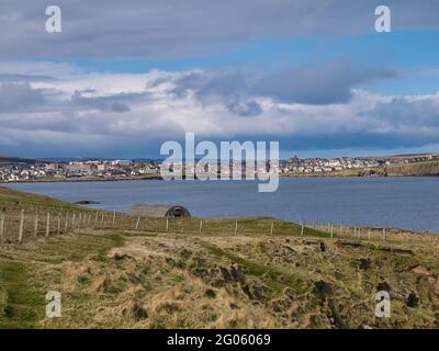 Across Bressay Sound, a view of Lerwick, the main town and port of the Shetland Islands, Scotland, UK - taken on a sunny day with blue sky and white c Stock Photo