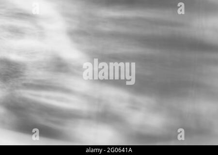 Glass drops diagonal shadow and light caustic effect on a white wall. Caustics formed by the refraction of the sun in a bottle on a light table. rays, Stock Photo