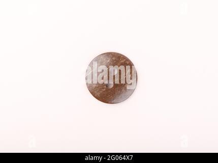 The brown plastic sewing button is marbled. Top view. Copy space. Stock Photo