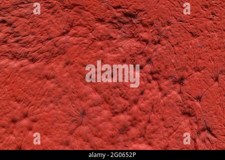 red sculpturesque plaster with decorative indentation finish wall texture and background Stock Photo