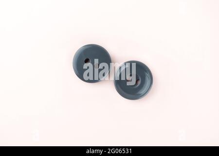 Two gray plastic buttons on both sides. Sewing accessories. Copy space. Stock Photo
