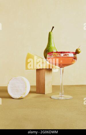 Still life with rose wine, cheese and pear. Front view on a beige background. Stock Photo