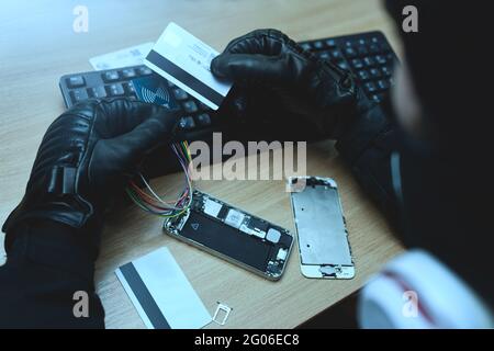 Hacking concept. Hacker trying to steal mobile payment information Stock Photo