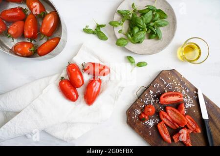 Ingredients for the preparation of  Salsa al Pomodoro or Passata di pomodoro, tomato perini, basil, salt and olive oil, traditional tomato sauce condi Stock Photo