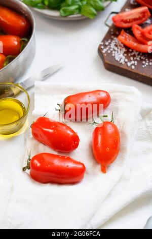 Ingredients for the preparation of  Salsa al Pomodoro or Passata di pomodoro, tomato perini, basil, salt and olive oil, traditional tomato sauce condi Stock Photo