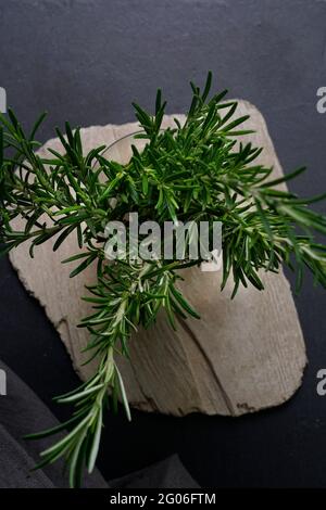 Jar of fresh rosemary on black slate background, Italy, Europe Stock Photo