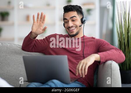 Positive arab guy working from home, having video conference Stock Photo