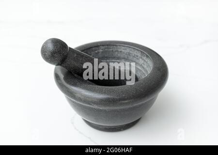 Black Stone Mortar and Pestle Isolated on White marble table Stock Photo
